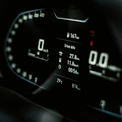 Close-up of a sleek digital car dashboard displaying speed and drive info.